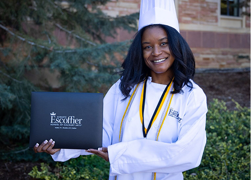 an escoffier culinary school graduate poses with her diploma an escoffier culinary school graduate poses with her diploma